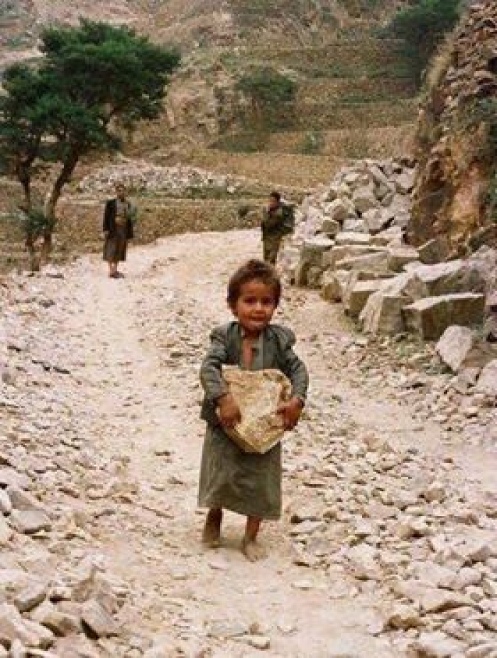 شاهد الصورة الأكثر تعليقاً وطرافة ... طفل يحمل حجراً ليودعه في البنك استجابة لخطاب الحوثي