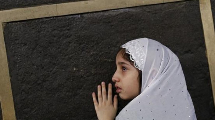 شاهد الصورة : طفلة تتعلق بأسوار الكعبة في مشهد تقشعر له الأبدان