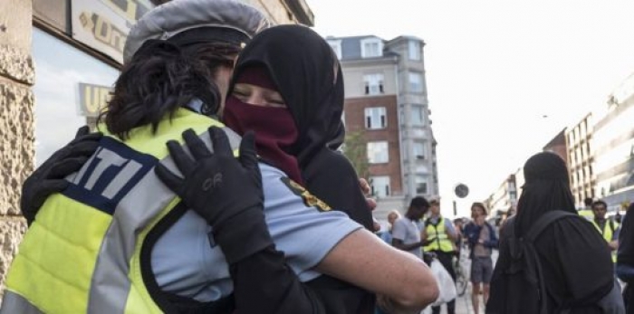 الدنمارك تحقق مع شرطية احتضنت محتجة منقبة
